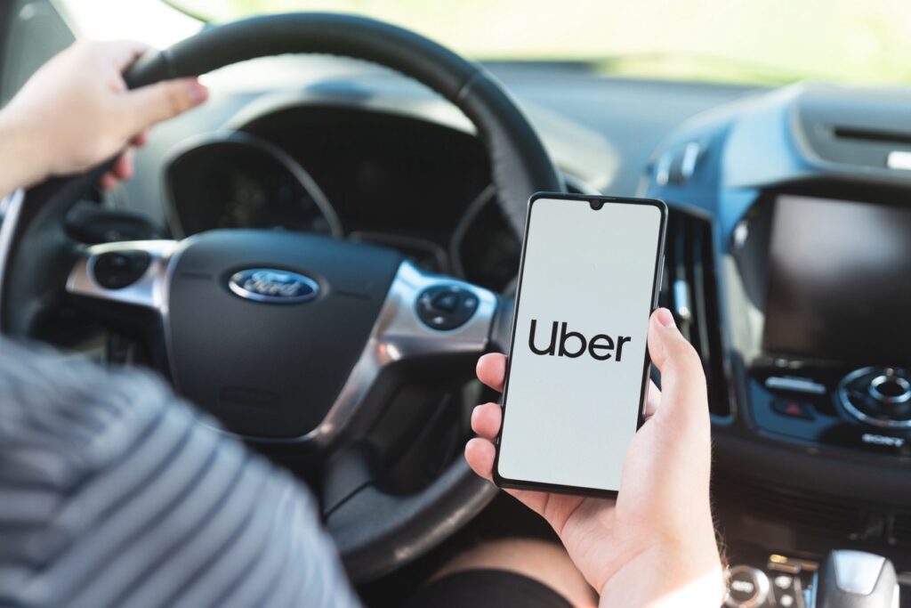 Uber driver holding smartphone in car